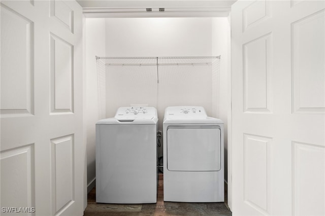 laundry area with washer and dryer and dark wood-type flooring