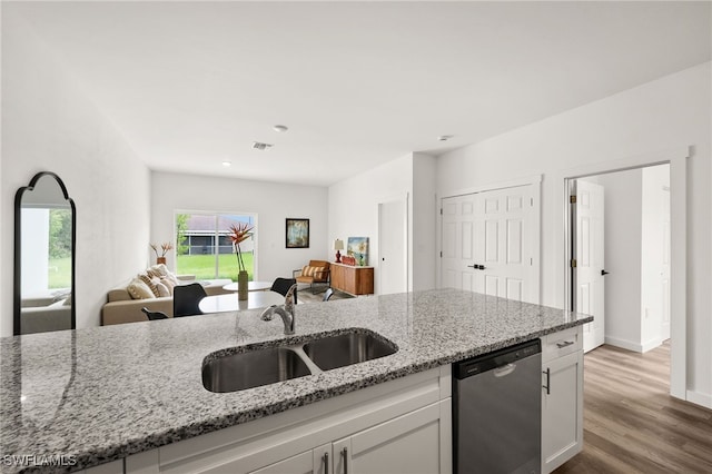 kitchen featuring dishwasher, light hardwood / wood-style flooring, sink, light stone counters, and white cabinets