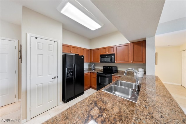 kitchen featuring stone counters, light tile patterned floors, black appliances, sink, and lofted ceiling