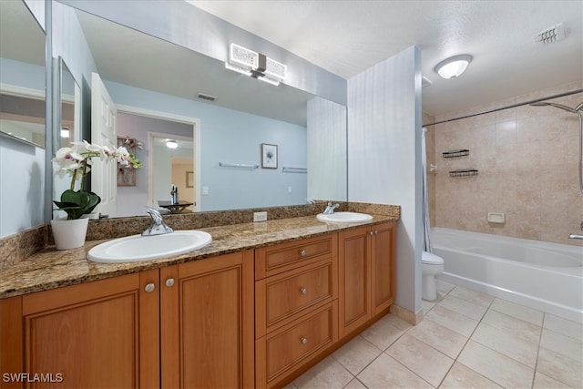 full bathroom with tile patterned flooring, vanity, toilet, and tiled shower / bath