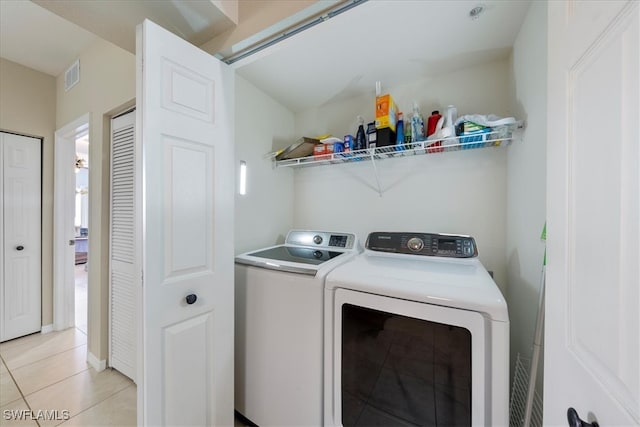 washroom with washing machine and dryer and light tile patterned floors