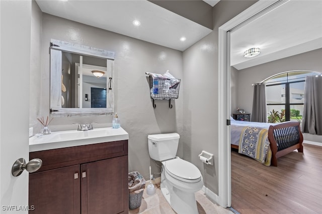 bathroom with hardwood / wood-style floors, toilet, and vanity