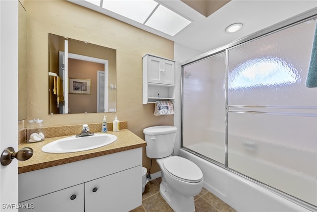 full bathroom featuring tile patterned floors, vanity, toilet, and combined bath / shower with glass door