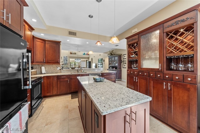 kitchen featuring a kitchen island, pendant lighting, kitchen peninsula, black electric range oven, and refrigerator