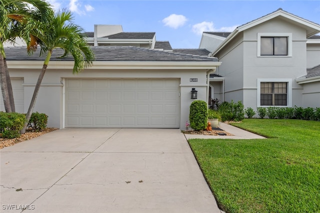 view of front of home with a front yard and a garage