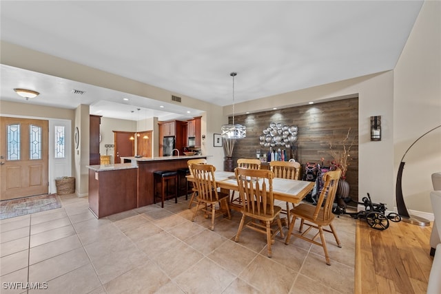 dining room featuring wood walls and light tile patterned floors