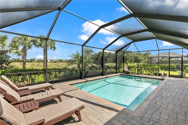 view of swimming pool featuring a lanai and a patio area