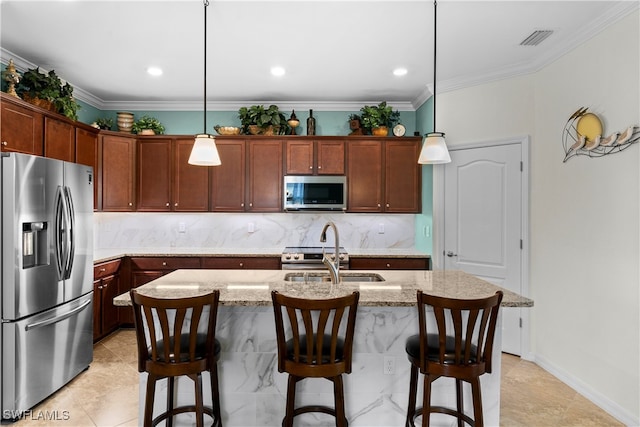 kitchen featuring pendant lighting, decorative backsplash, stainless steel appliances, and a kitchen island with sink