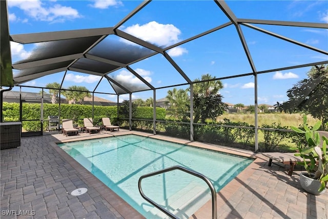 view of swimming pool featuring glass enclosure and a patio area