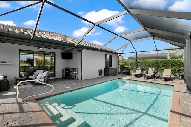 view of swimming pool featuring a lanai, ceiling fan, and a patio area