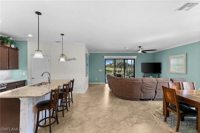 living room featuring ceiling fan, sink, and crown molding