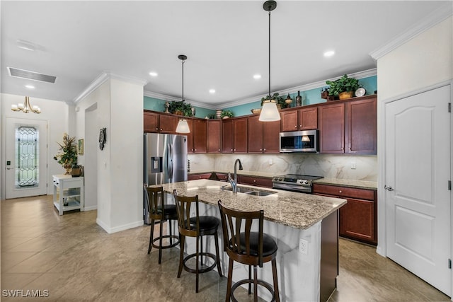 kitchen featuring pendant lighting, a kitchen breakfast bar, sink, an island with sink, and appliances with stainless steel finishes