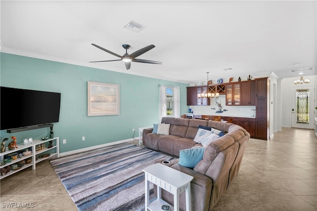 living room with ceiling fan with notable chandelier, light tile patterned floors, crown molding, and a wealth of natural light