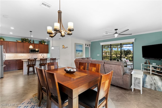 dining space with sink, light tile patterned flooring, ceiling fan with notable chandelier, and ornamental molding