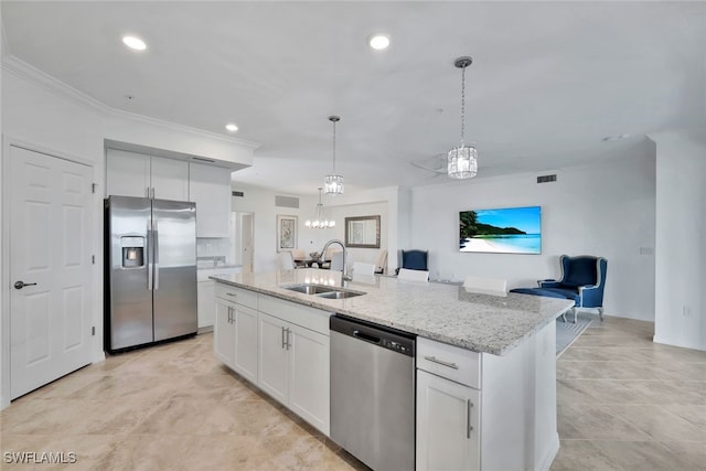 kitchen with white cabinets, sink, appliances with stainless steel finishes, and an island with sink