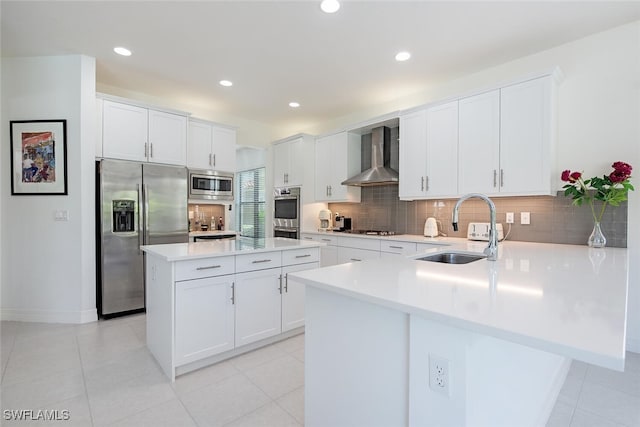 kitchen featuring backsplash, a center island, sink, wall chimney exhaust hood, and built in appliances