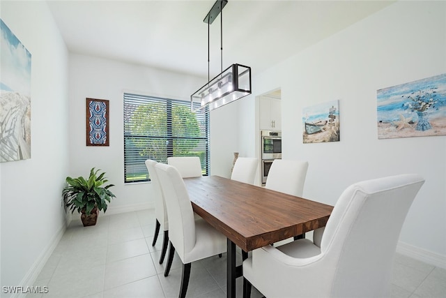 tiled dining area featuring an inviting chandelier