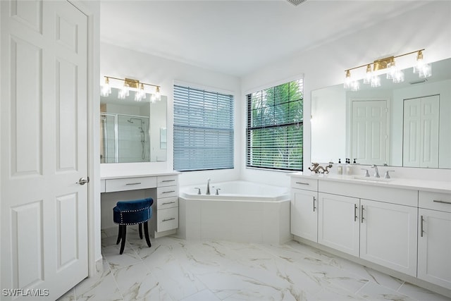 bathroom with vanity and shower with separate bathtub