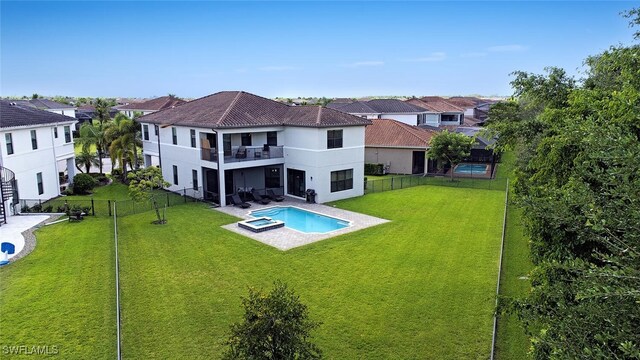 rear view of property with a balcony, a yard, and a patio