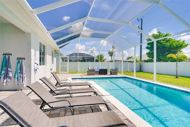 view of swimming pool with outdoor lounge area, glass enclosure, and a patio area