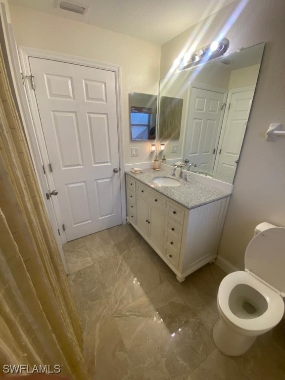 bathroom featuring toilet and vanity