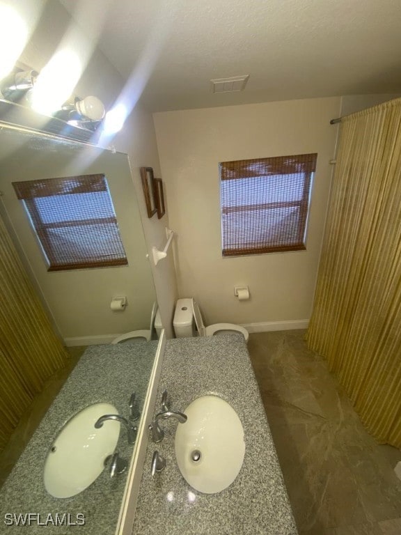 bathroom featuring toilet, vanity, and a textured ceiling