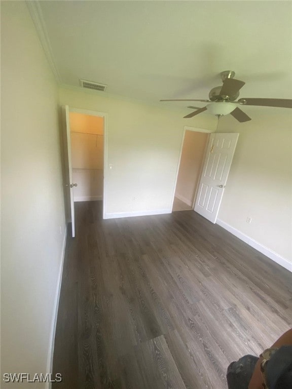 interior space with ceiling fan, dark hardwood / wood-style flooring, and ornamental molding