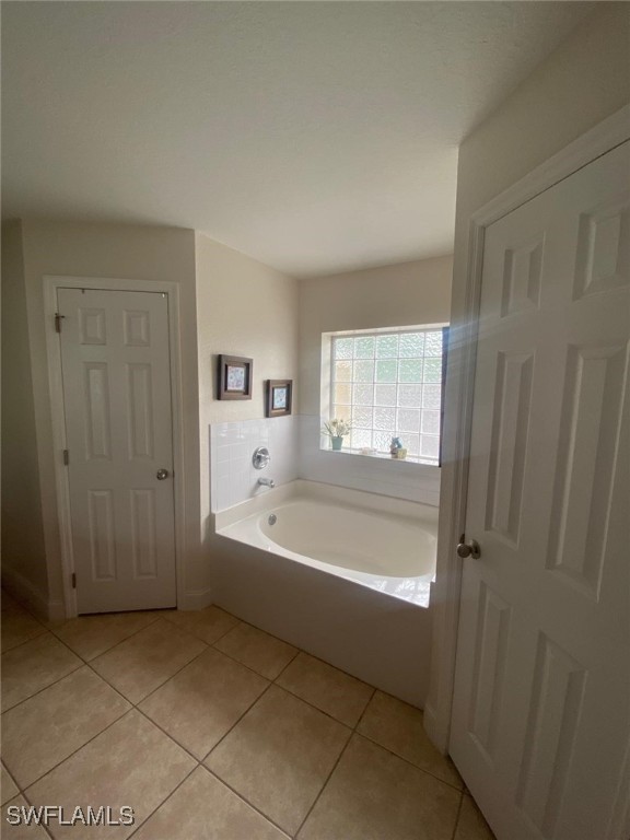 bathroom featuring tile patterned flooring and a bath