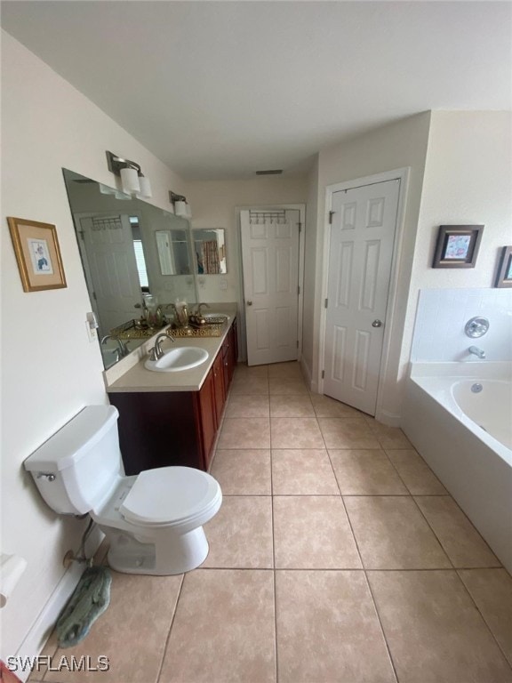 bathroom featuring tile patterned flooring, vanity, toilet, and a bath