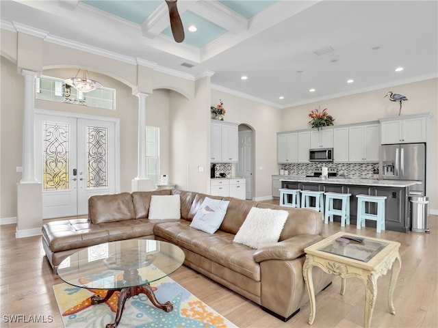 living room featuring beamed ceiling, ornate columns, coffered ceiling, french doors, and ornamental molding