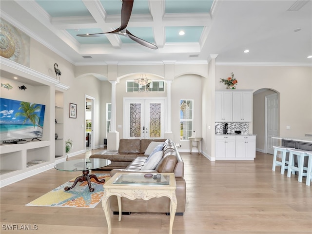 living room featuring crown molding, coffered ceiling, beamed ceiling, and a wealth of natural light