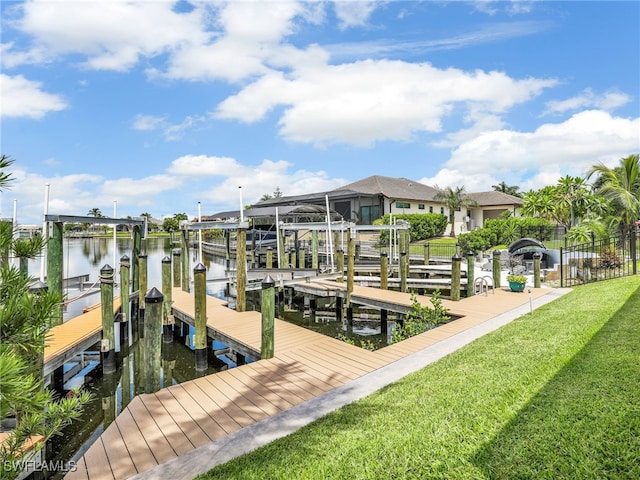 view of dock with a lawn and a water view