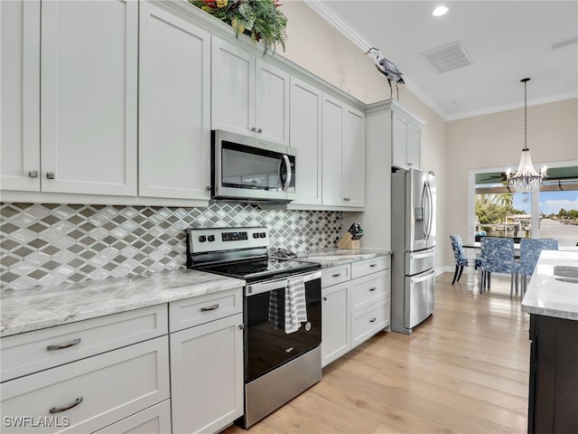 kitchen featuring stainless steel appliances, white cabinetry, and ornamental molding