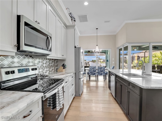 kitchen featuring light stone countertops, white cabinetry, and appliances with stainless steel finishes