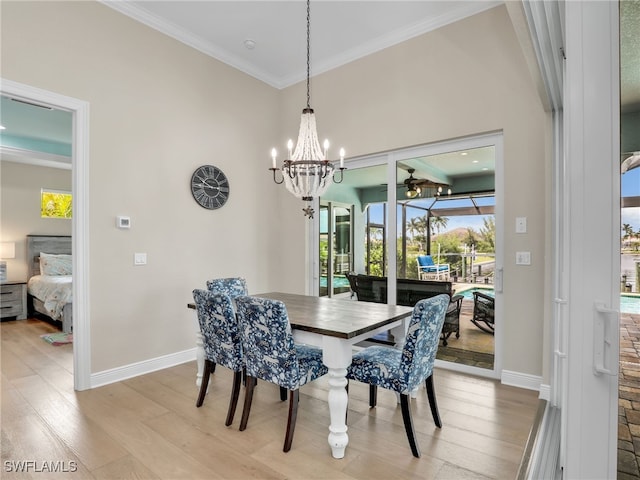 dining space with ornamental molding, vaulted ceiling, light hardwood / wood-style flooring, and an inviting chandelier