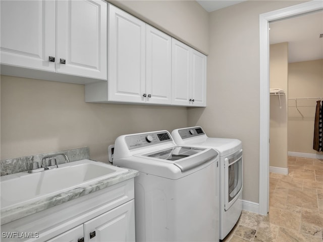 clothes washing area with sink, cabinets, and washing machine and dryer