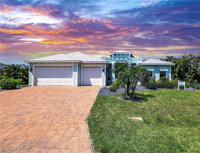 view of front of property featuring a garage and a yard