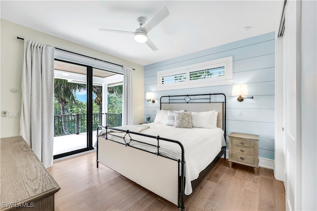 bedroom featuring access to exterior, wood-type flooring, multiple windows, and ceiling fan