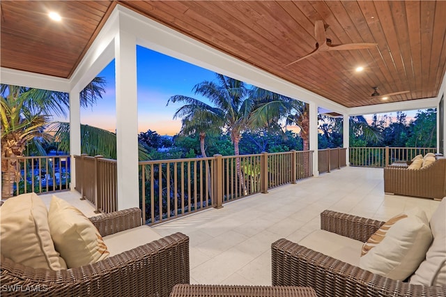 patio terrace at dusk featuring outdoor lounge area and ceiling fan