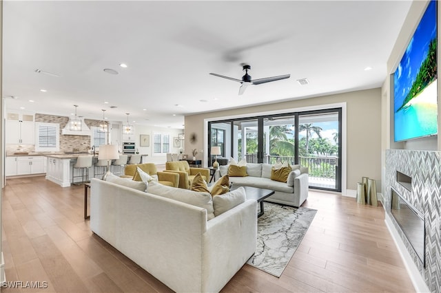 living room featuring ceiling fan and light hardwood / wood-style floors