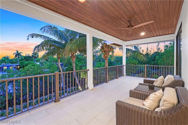 patio terrace at dusk with ceiling fan and a balcony