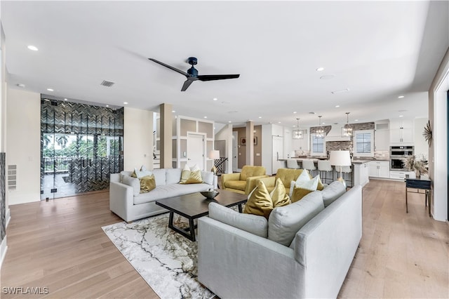 living room with ceiling fan and light wood-type flooring