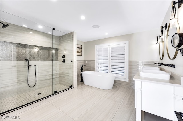 bathroom featuring vanity, tile patterned floors, tile walls, and independent shower and bath