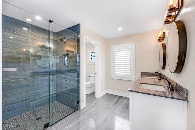 bathroom with vanity, toilet, and an enclosed shower