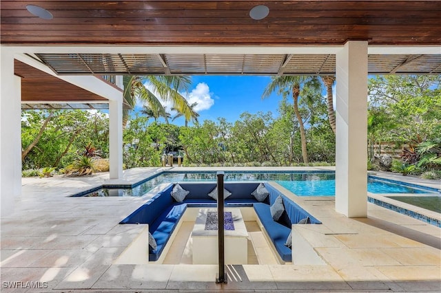 view of swimming pool featuring a patio and a hot tub