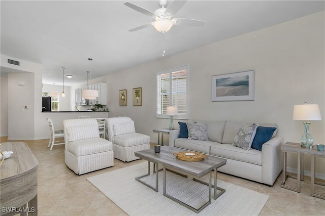 living room with ceiling fan, light tile patterned floors, and a healthy amount of sunlight