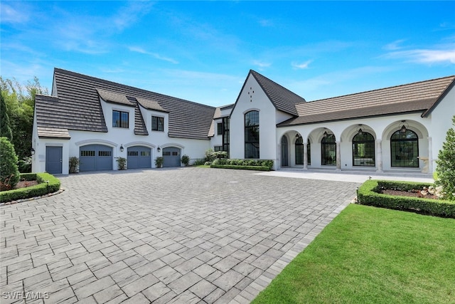 french country home with a garage and a front lawn