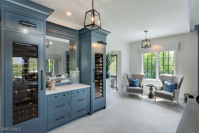 bar with blue cabinetry, pendant lighting, and wine cooler