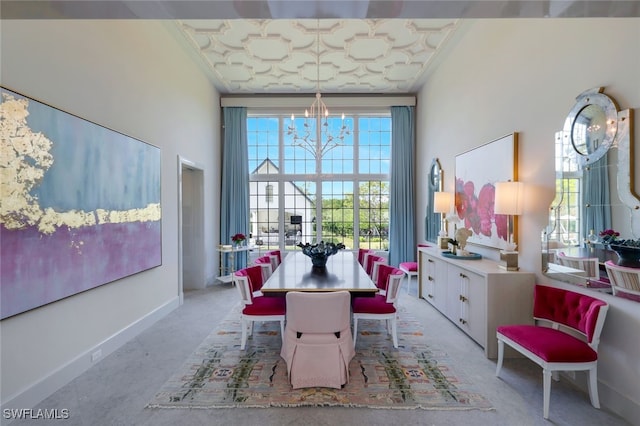 dining space featuring a towering ceiling, a notable chandelier, and ornamental molding