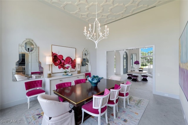 254 Audubon Blvd, Naples, FL 34110 - dining room with a notable chandelier, baseboards, and a towering ceiling